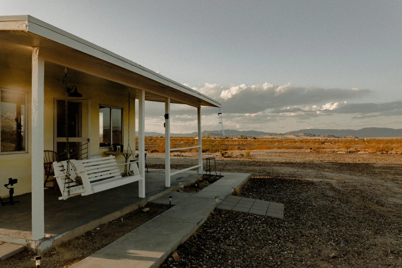 the small house has white painted siding on the porch