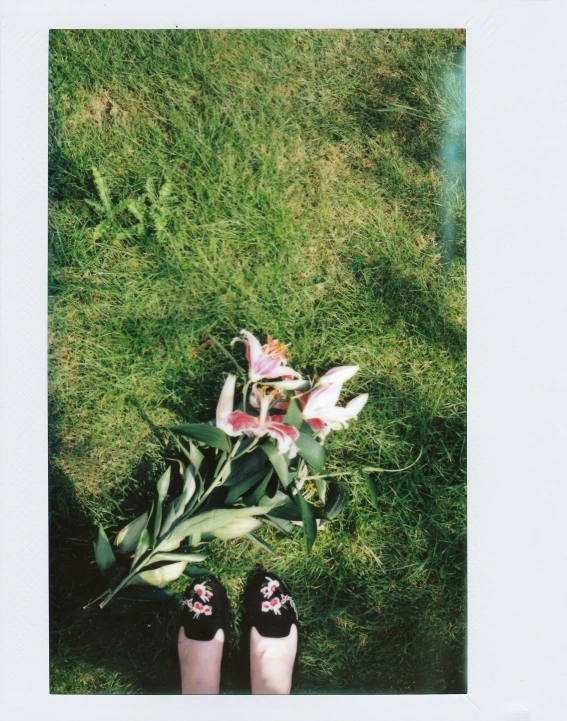 the bottom of a woman's legs and flower bouquet in her hands