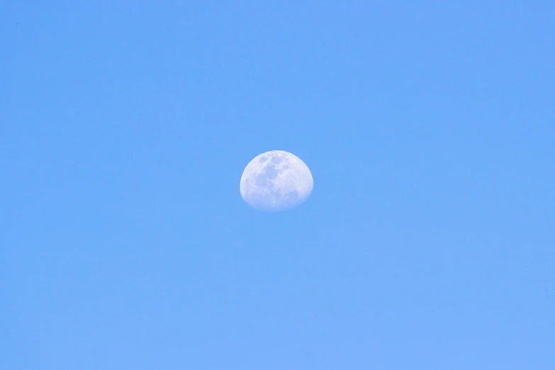 a plane flies in the sky under the moon