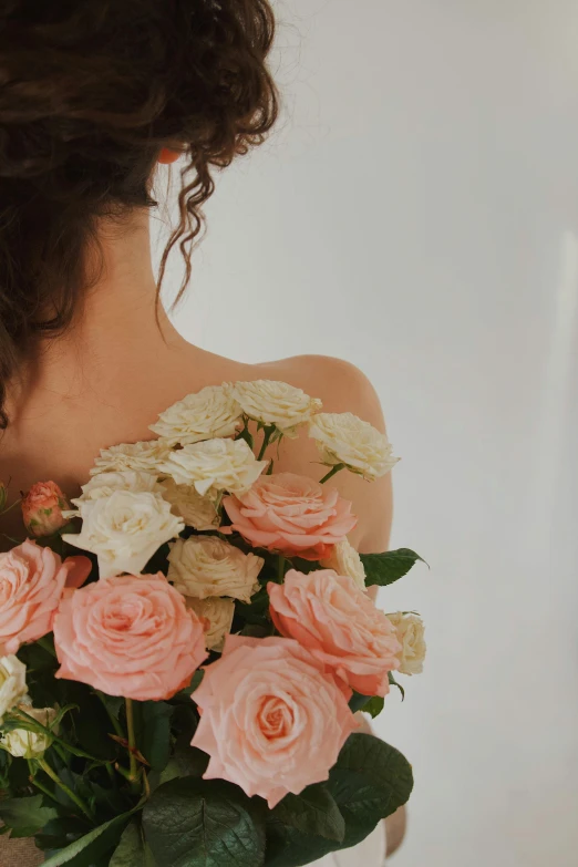 a girl holding a bouquet of pink roses