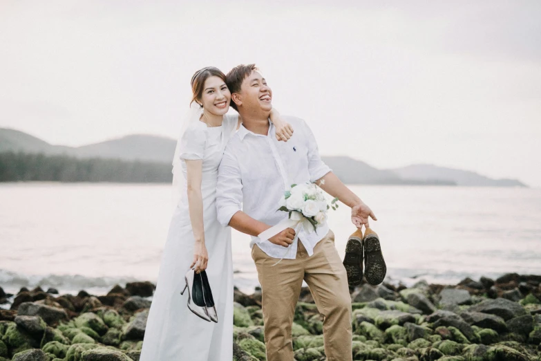 a man and a woman standing together by the ocean