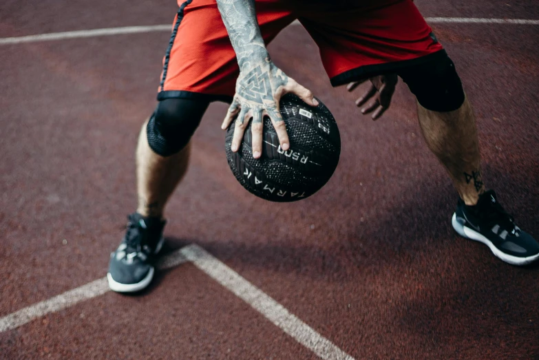 the arm and foot of a basketball player holding a ball