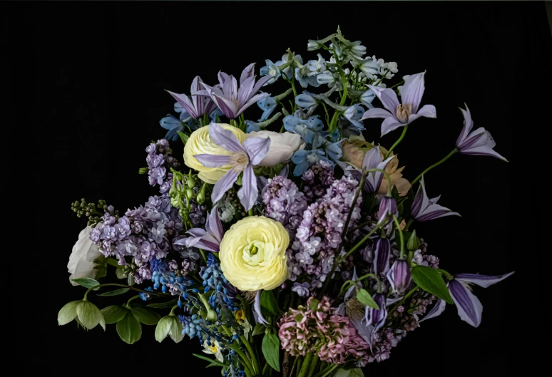 a vase filled with purple, white and yellow flowers