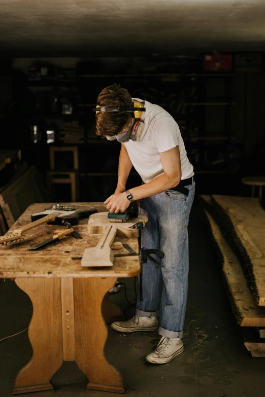 a man  a piece of wood with a table saw