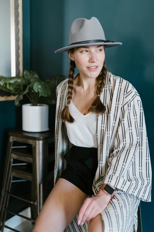 woman wearing a fedora sitting in a chair