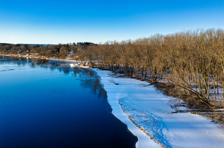 a lake with ice covered water surrounded by trees