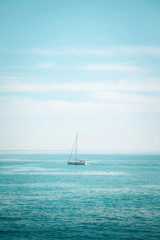 a sail boat sailing across open water with no waves