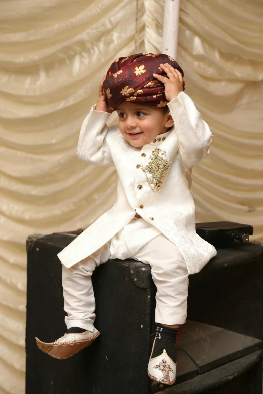 a child in a tuxedo and jacket on a wooden step