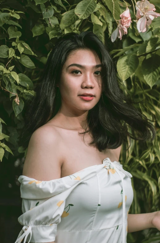 a woman poses for the camera while wearing an off shoulder dress