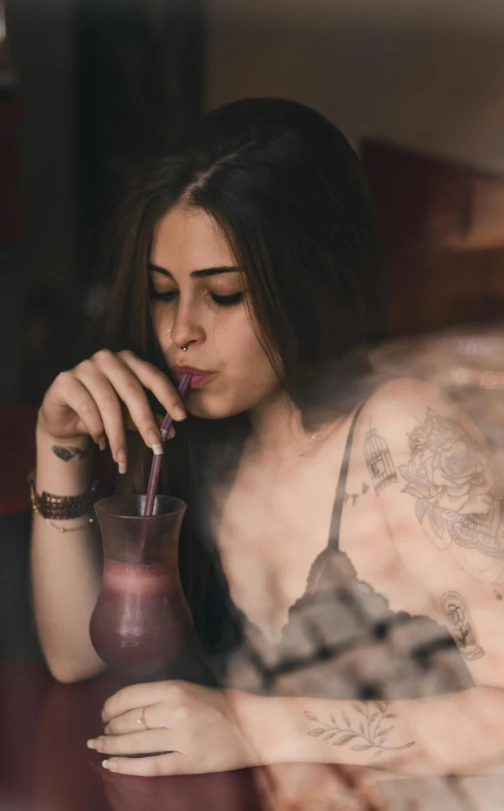 a woman in black shirt sipping from a glass