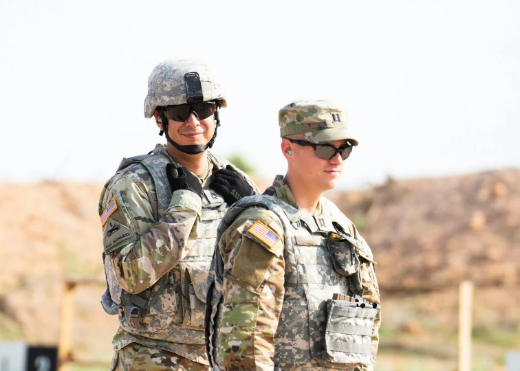 two soldiers are standing side by side wearing uniforms