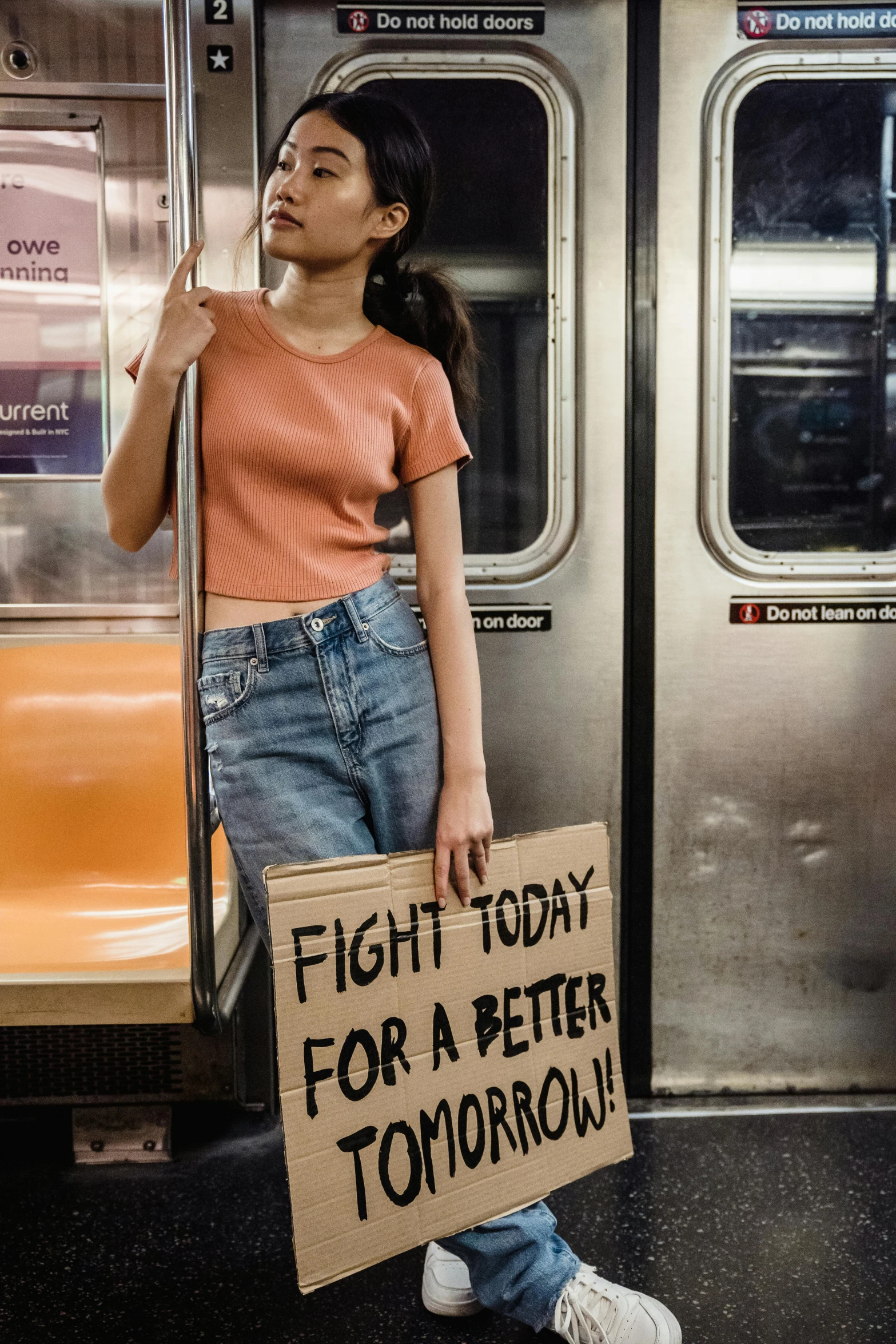 a woman holding a sign that says fight today for a better tomorrow