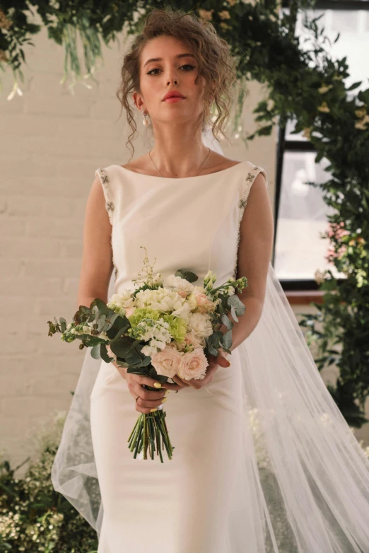 a woman in a white wedding gown holding a bouquet