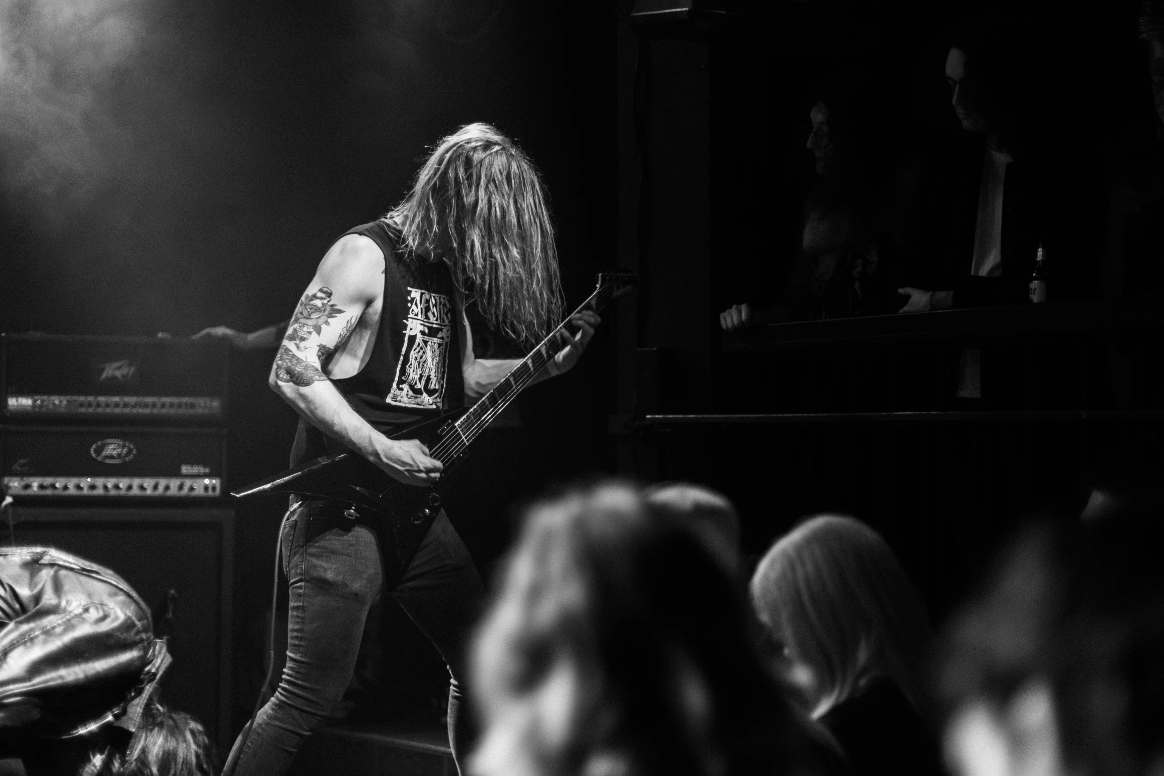 a man playing a guitar in front of other people