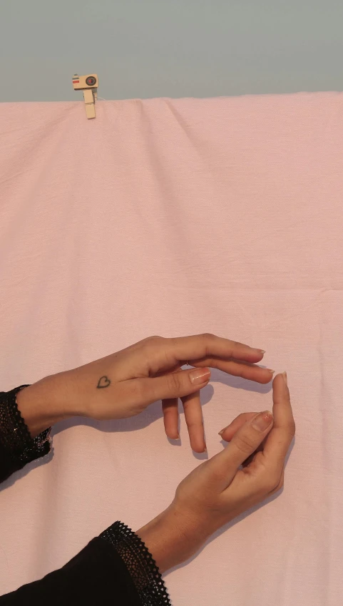 a woman's hand on top of the bed with her fingers reaching for the finger