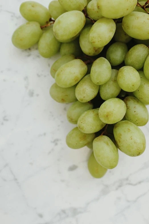 a cluster of green gs are on the marble surface