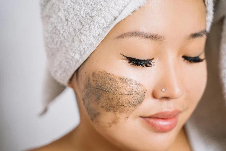 a woman with her face covered in sand, with makeup on her face