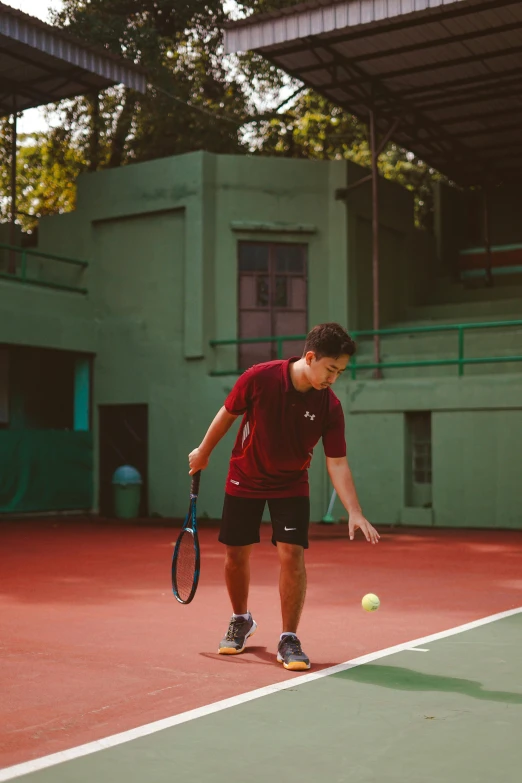 a man in a red shirt and black shorts is playing tennis