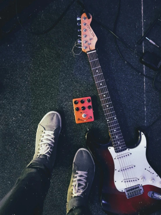 a person standing next to an electric guitar