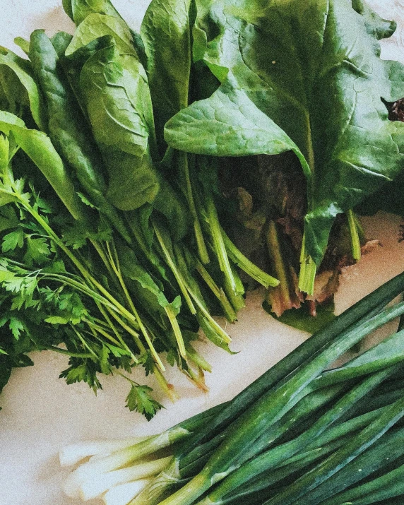 a couple of bunches of fresh vegetables sitting next to each other