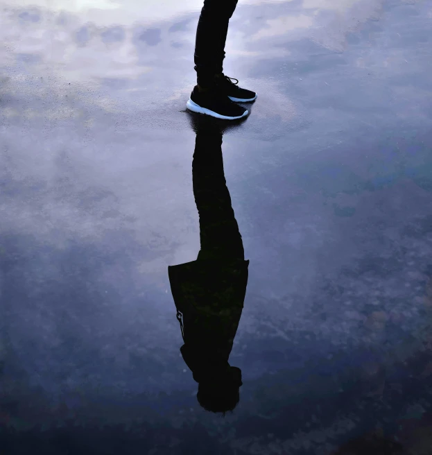 a skateboarder is skating down a reflective surface