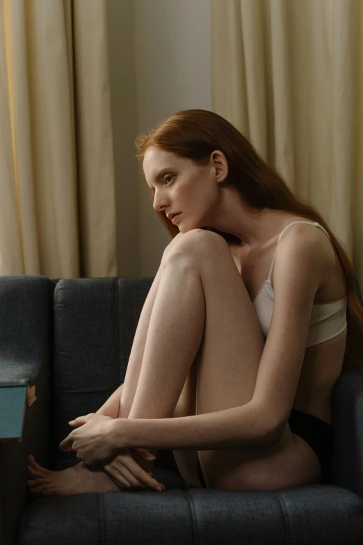 a woman with red hair and  sits on the couch