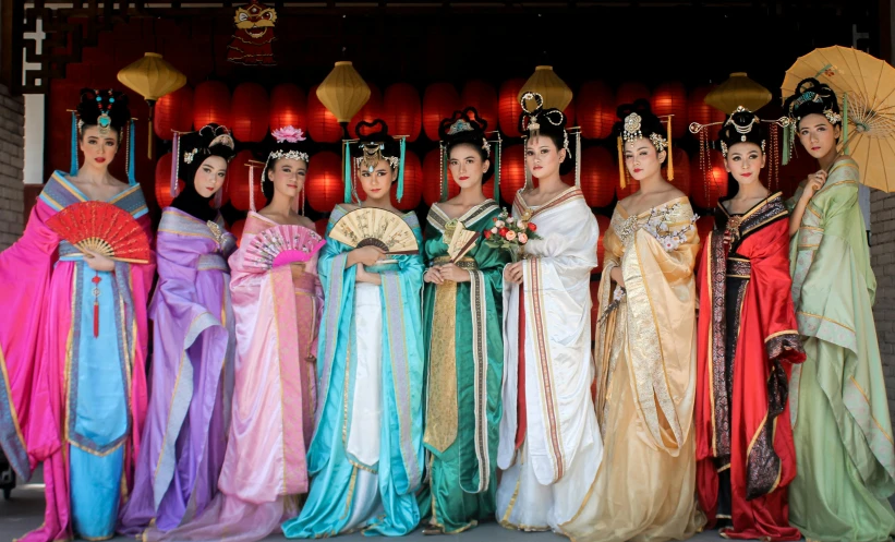 asian women dressed in long gowns standing together