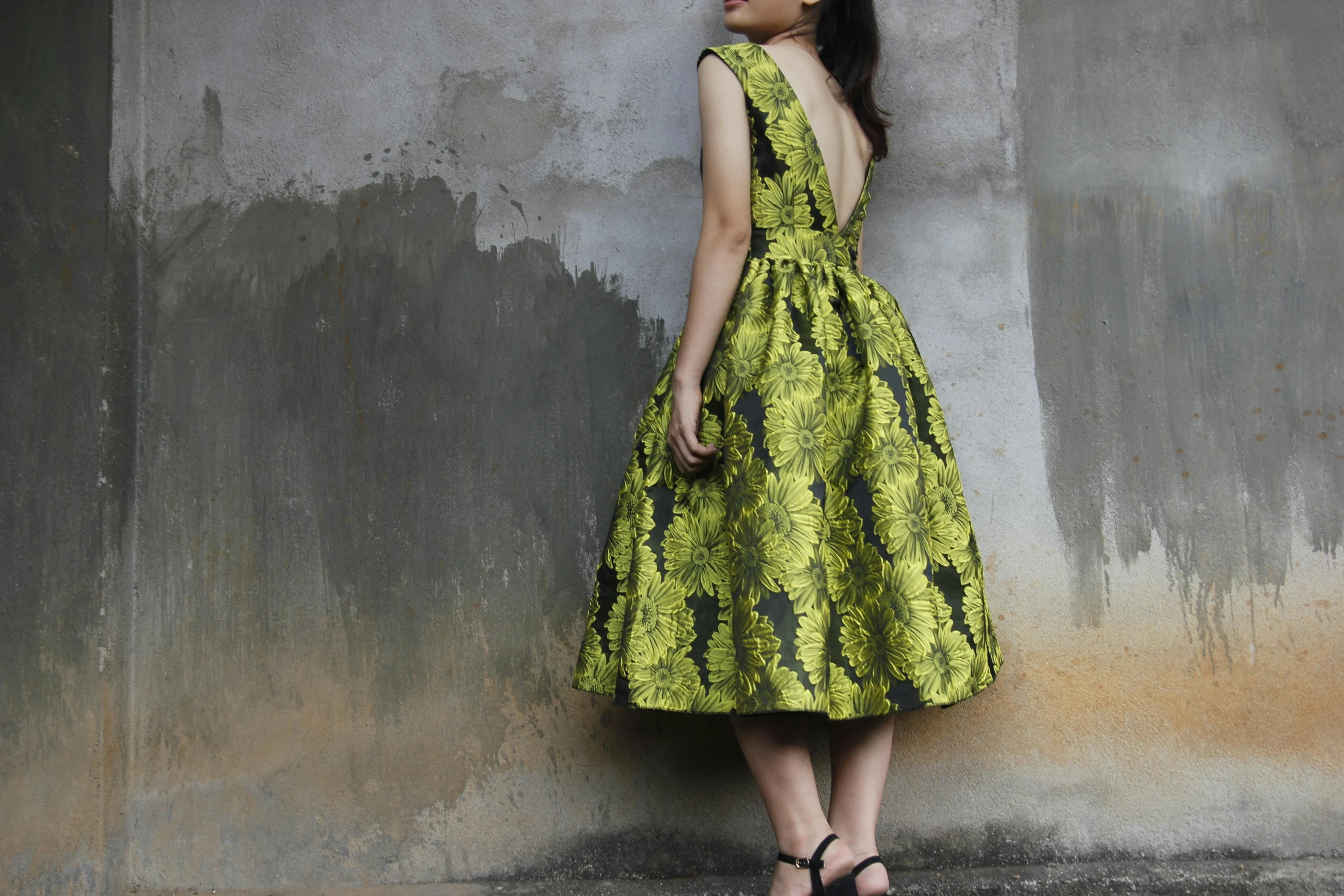 a woman with black hair and bright yellow dress