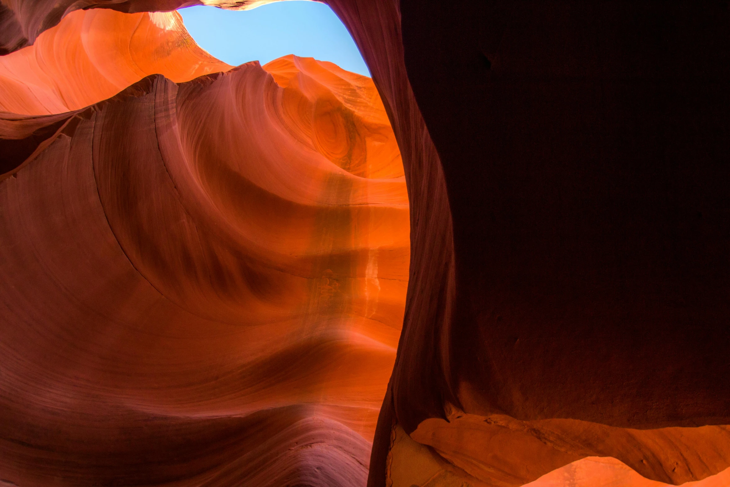 the light shines in from a small window at a tall rock formation