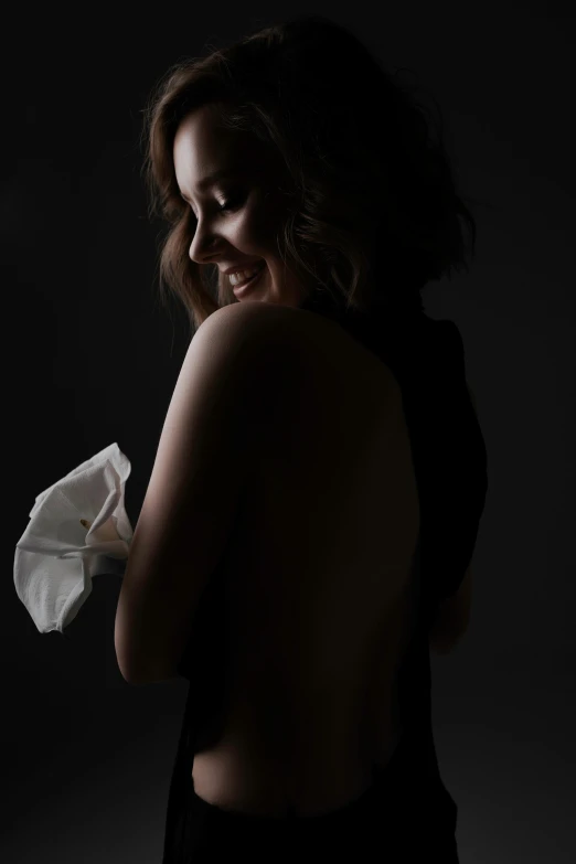 a woman holding a piece of tissue next to her shoulder