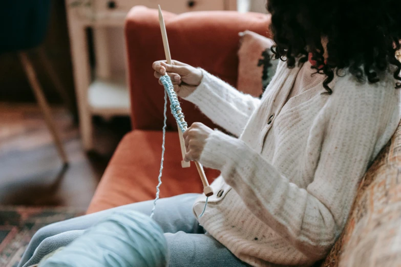 a person that is sitting down with some yarn