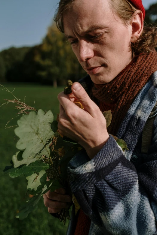 a man holds a bunch of ivy in his hands