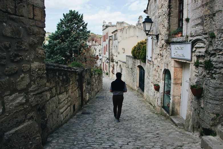 a person that is walking down a narrow alley way