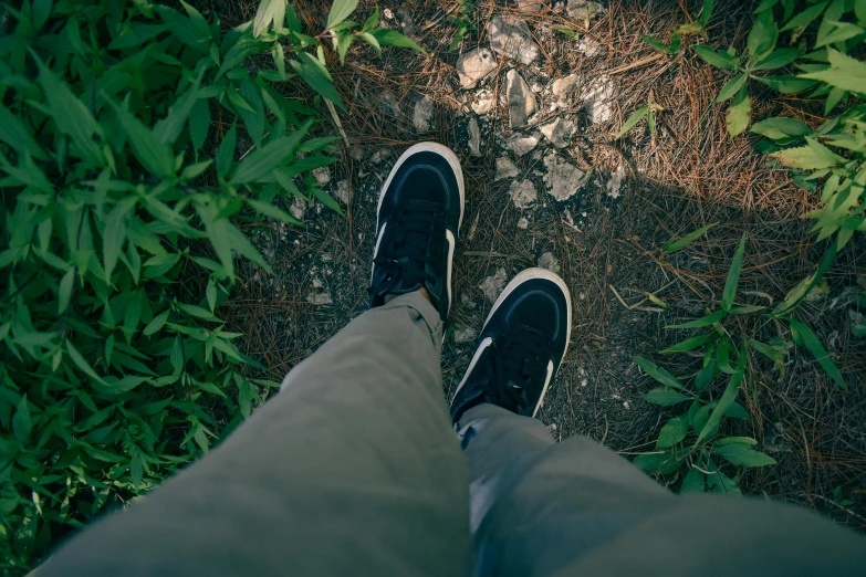 person standing on the grass looking down at their shoes