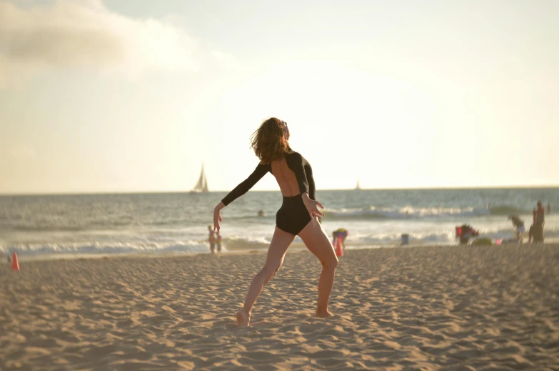 a woman on the beach with her arm outstretched