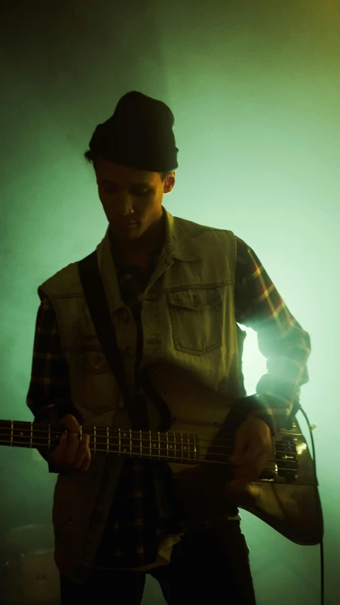 a person is playing guitar in the dark