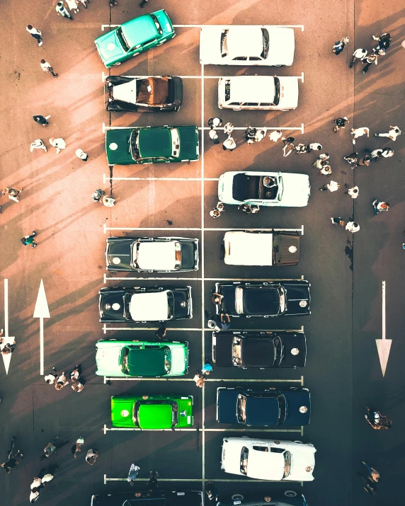 several cars parked in a lot with a number of green and white ones