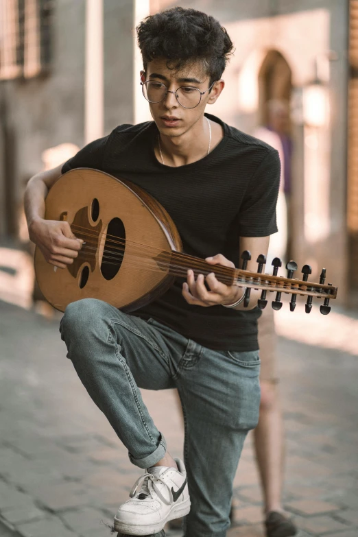 a person squatting with a guitar in their hands