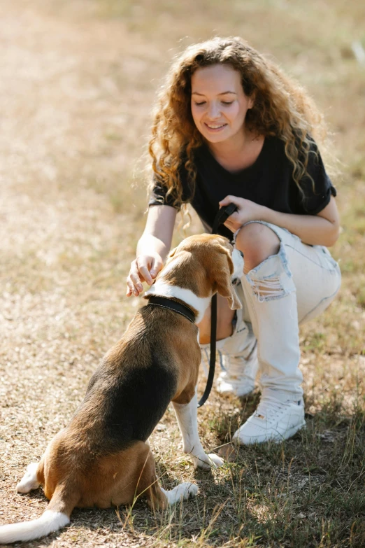 a woman is playing with her dog outside