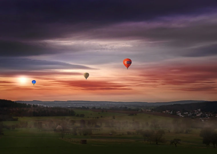 two  air balloons flying over a field