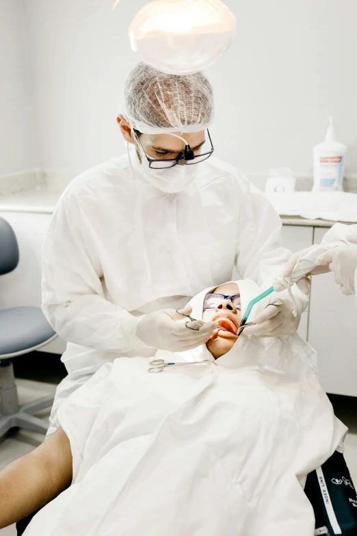 a dentist is performing dental work on a patient
