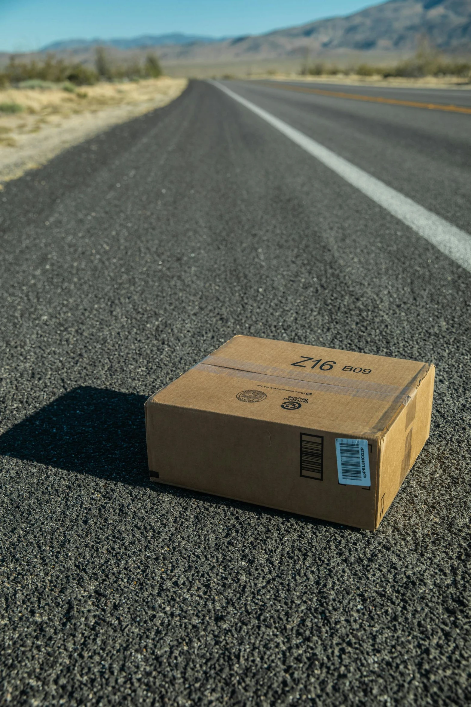 a box sits on the side of a long road