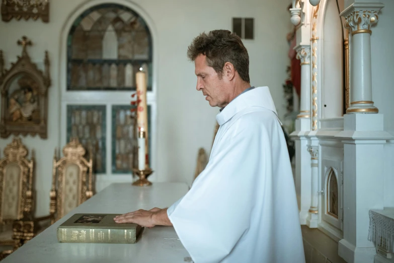 a man in a white robe holding a book