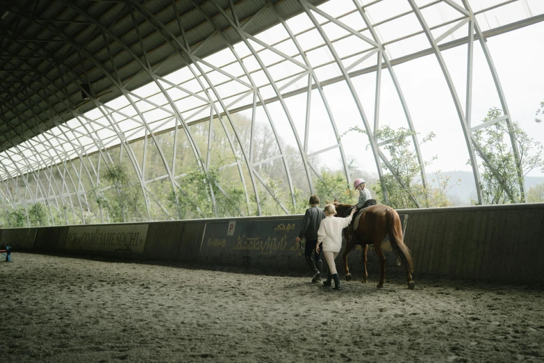 people standing by a building with horses on the side