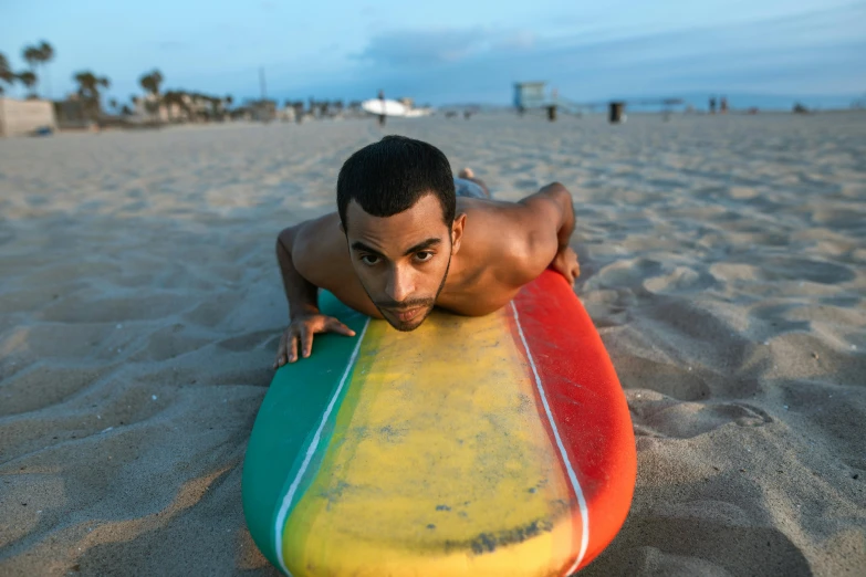 a man laying on a surfboard at the beach