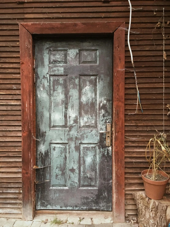 an old rusty gray metal door with brown trim