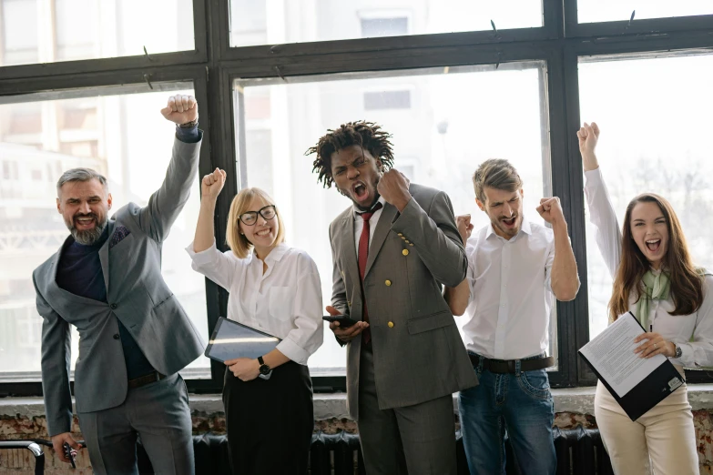 several people all raising their hands in the air