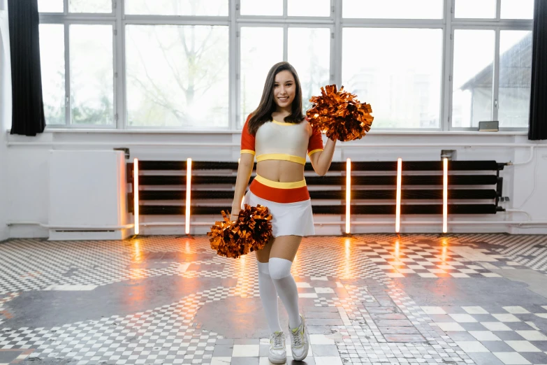 a woman is standing in the middle of a room with some cheerleader's