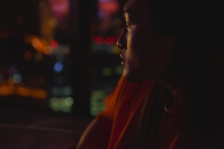 the head of a man with orange robes and headbands in the dark