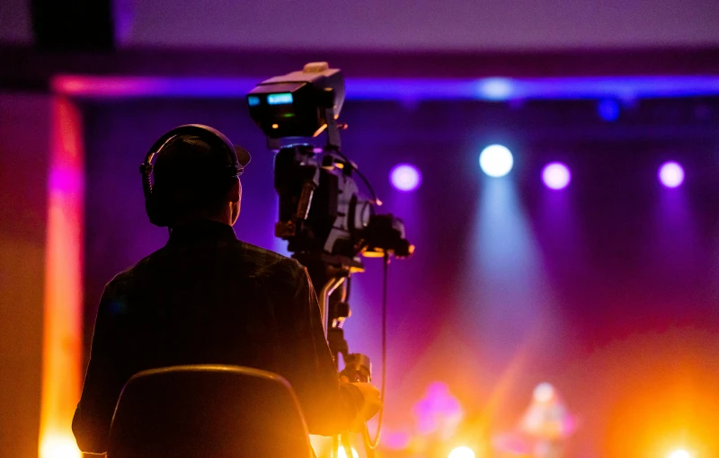 a cameraman wearing headphones is recording a concert with sound equipment